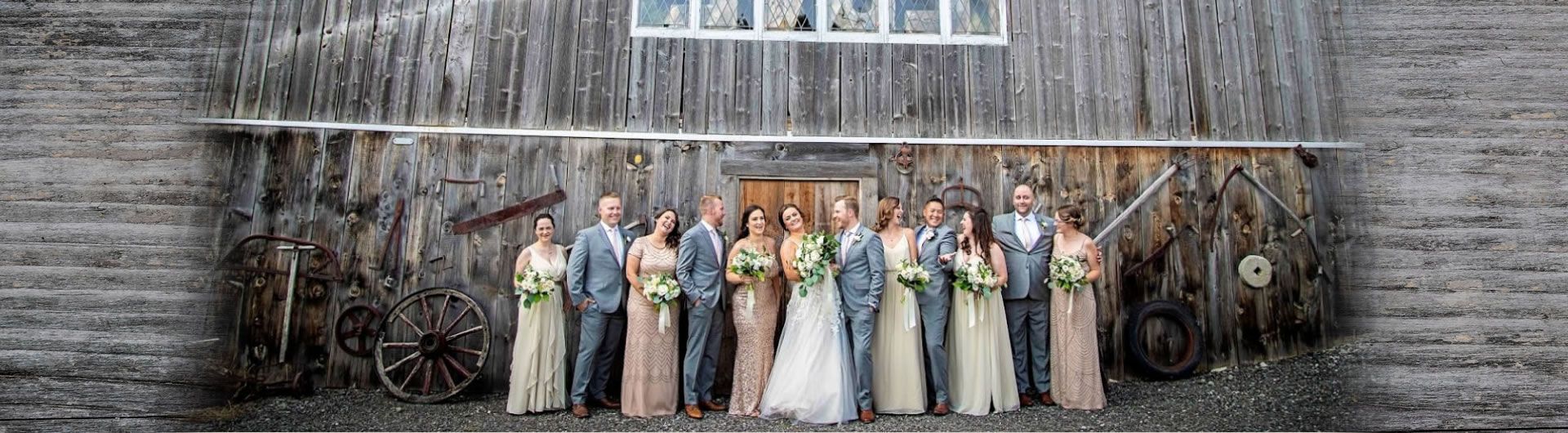 Wedding party posing in front of barn